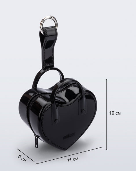 Angled view of a black Heartbeat Pocket bag charm with measurements of 11cm x 5cm x 10cm
