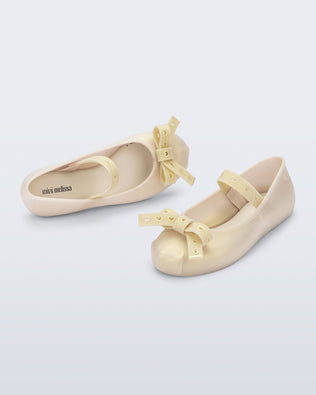 Top and angled view of a pair of pearly beige Sophie Crush kids ballerina flats with bow