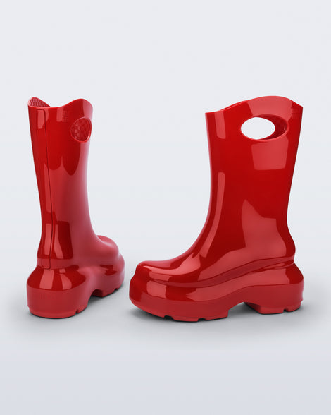 Back and side view of a pair of red Ultra platform rain Boot with circle cutout on top