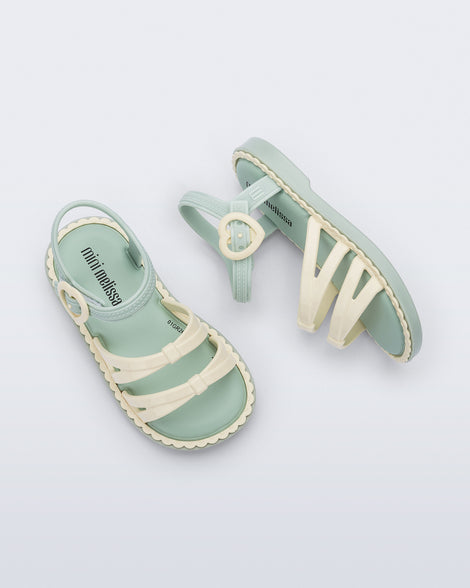 Side and top view of a pair of green Aurora baby sandals with beige trim, straps and buckle