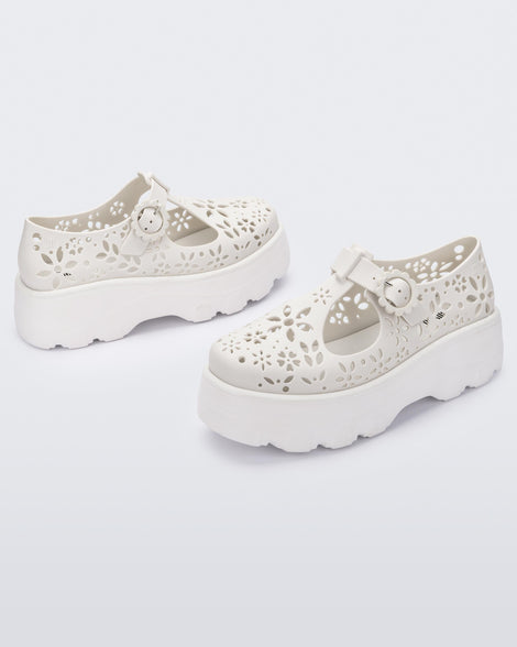 Angled view of a pair of white Kick Off Lace women's platform shoe with buckle.