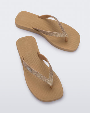 Top view of a pair of beige with brown glitter strap Sun Long Beach flip flop