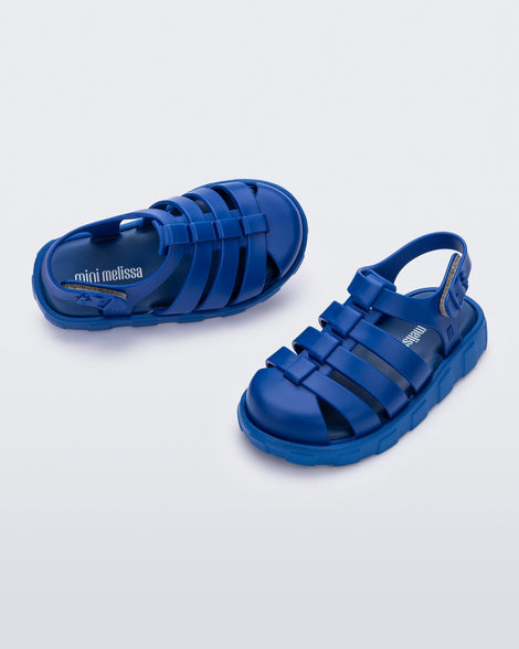 Angled view of a pair of blue Megan baby sandals.