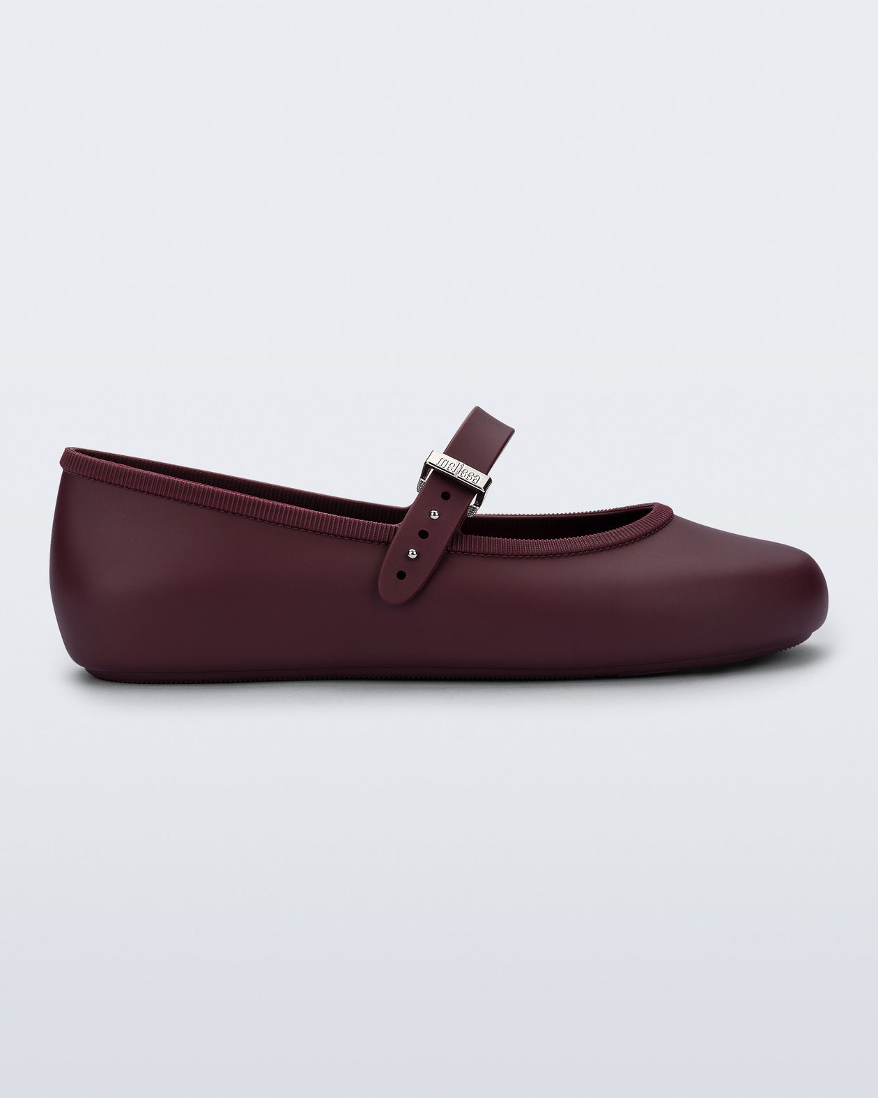 Side view of a burgundy Soft Ballerina flat with top strap and silver buckle