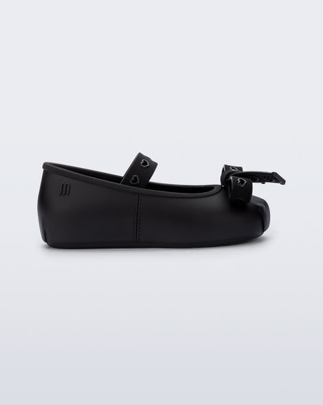 Side view of a black Sophie Crush baby ballerina flat with bow