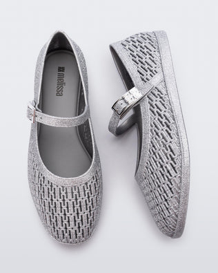 Top and side view of a pair of silver glitter Harper flat with strap