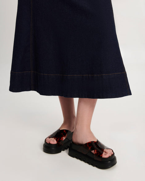 Model's legs wearing a pair of black/tortoise Cozy Cross platform sandals with crisscross top straps