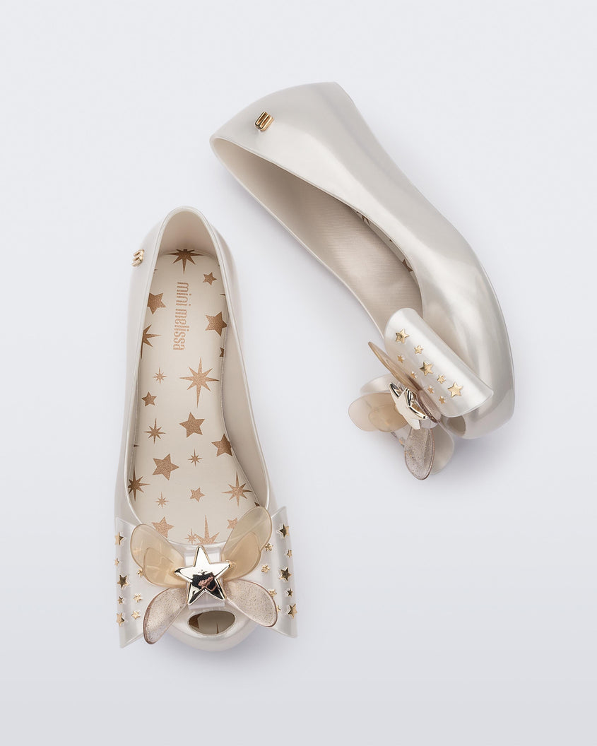 Top and side view of a pair of Mini Melissa Ultragirl peeptoe ballet flats in white with star printed butterfly bow applique. 