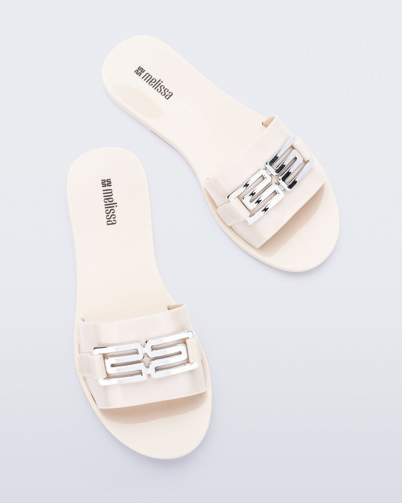 Top view of a pair of beige Babe M Chic slide sandals