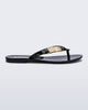 Side view of a black Harmonic M Chic flip flop