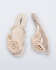 Top and side view of a pair of beige Harmonic Petals kids flip flops with flowers