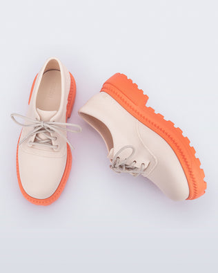 Top and side view of a pair of beige with orange sole Charlotte adult sneaker loafers with laces