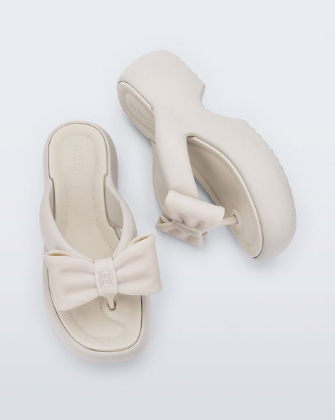 Side and top view of a pair of beige Free Fuzzy Platform flip flops