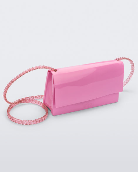 Angled view of the Melissa party handbag in pink with braided strap.