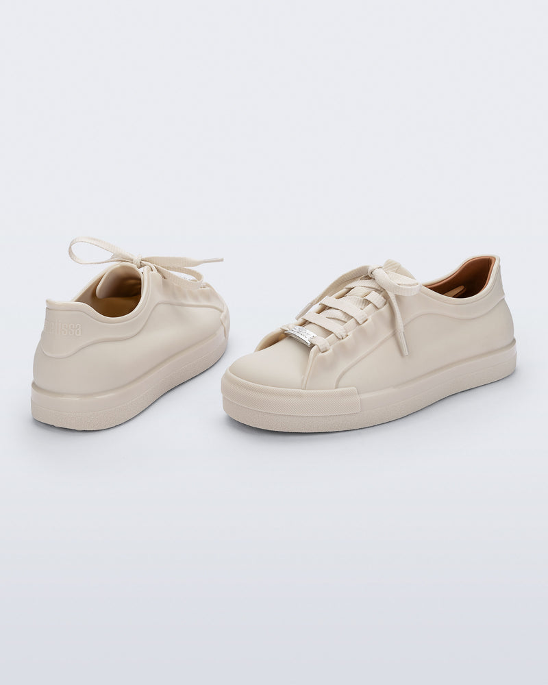 Back and angled view of a pair of beige Wow Sneakers with beige laces