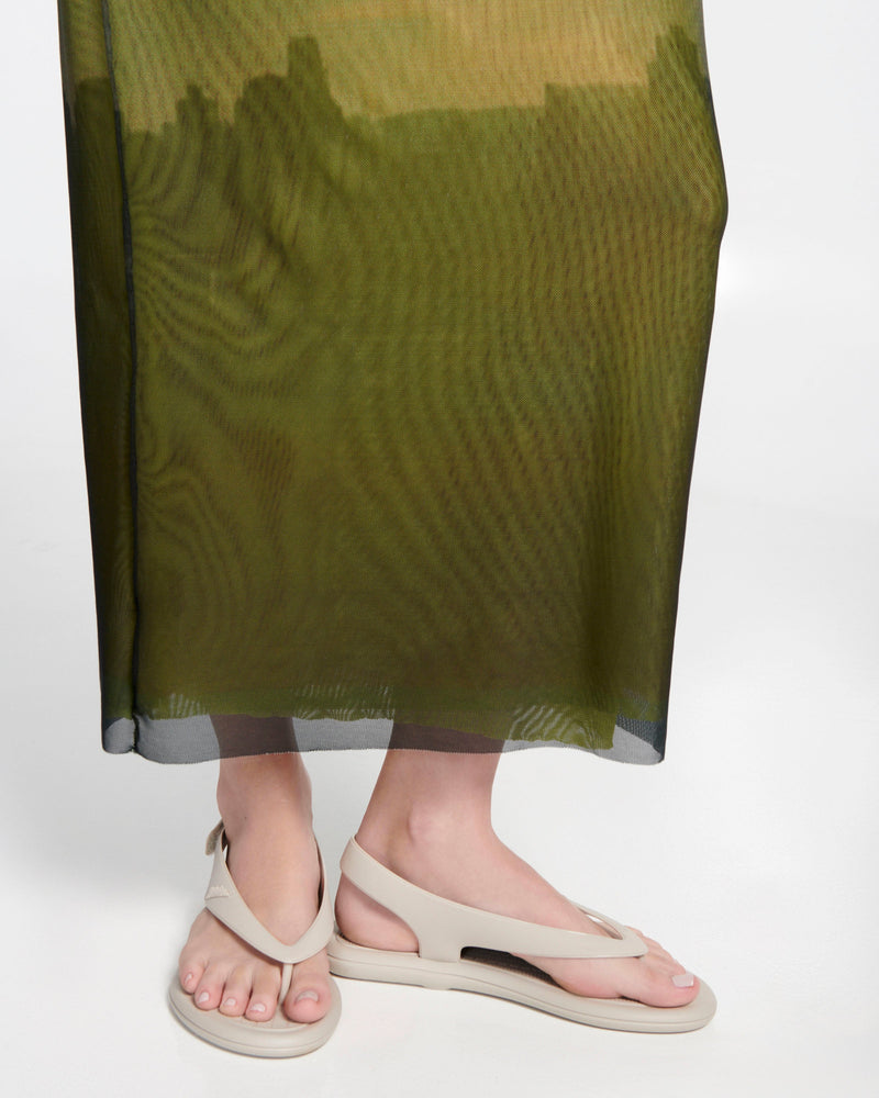 Model's legs in a green dress wearing a pair of beige Sun Samba thong sandals