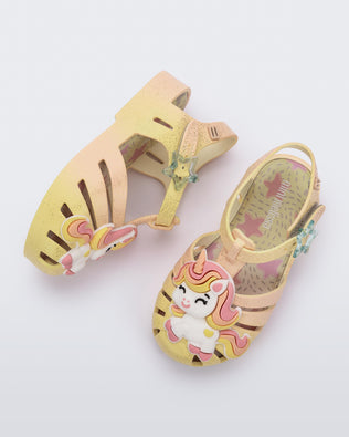 Side and top view of a pair of yellow/pink Possession Unicorn baby sandals with unicorn on front upper
