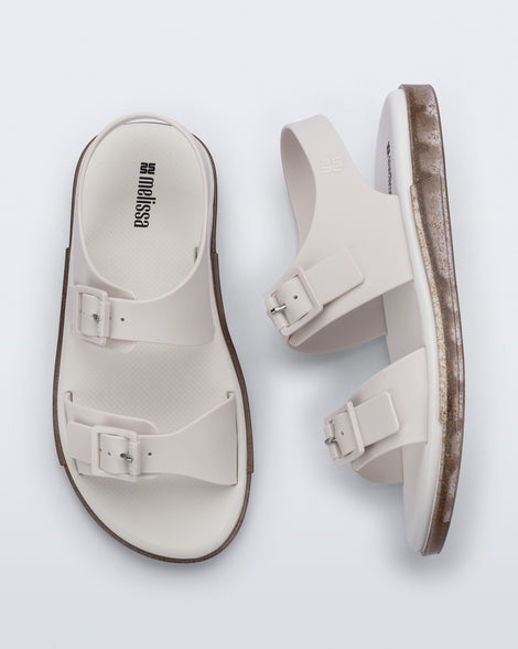 Side and top view of a pair of beige Wave Sandals with two straps with buckles and a back strap