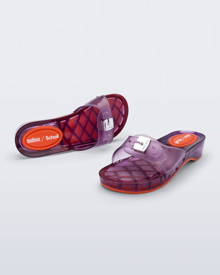 Top and angled view of a pair of clear lilac Pescura Heel + Scholl slides with top buckle