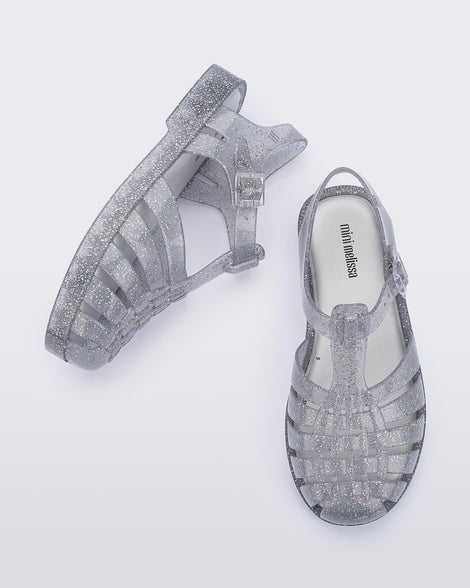 Top and side view of a pair of glitter/clear/silver Possession kids fisherman sandals