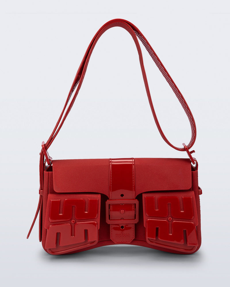 Front view of a red Cargo bag with two small pockets on the front and an adjustable strap