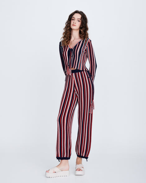 Model in a stripped long sleeved pant suit wearing a pair of beige M Lover Cross Strap platform slides