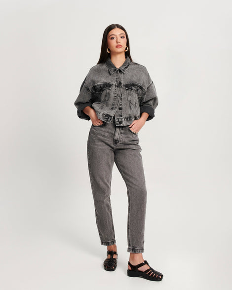 Model in black jean pants and jacket wearing a pair of black Possession Pescura + Scholl fisherman sandals