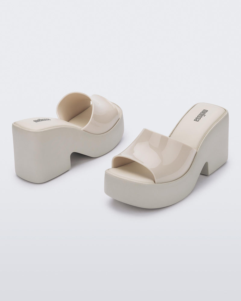 Back and angled view of a pair of beige Posh platform heels