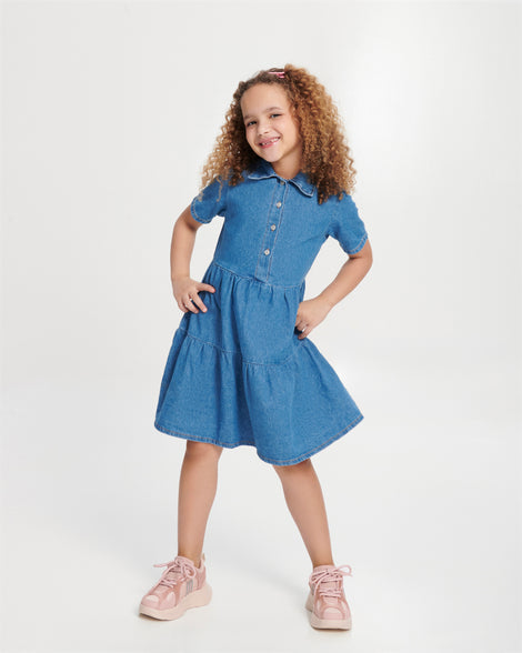 Child model in a blue dress wearing a pair of pink X Beat kids sneakers