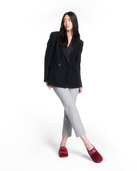 Model in grey capris and black blazer wearing a pair of red Cozy Clog Velvet slides