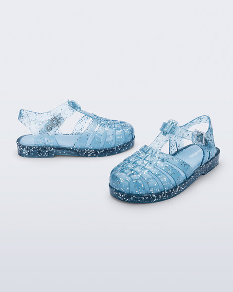 Side and angled view of a pair of blue Possession kids sandals with heart glitter