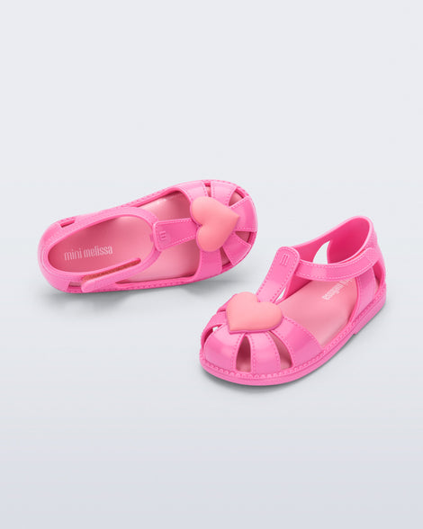 Side and top view of a pair of pink Hip Heart Ballerina baby sandals with heart on front