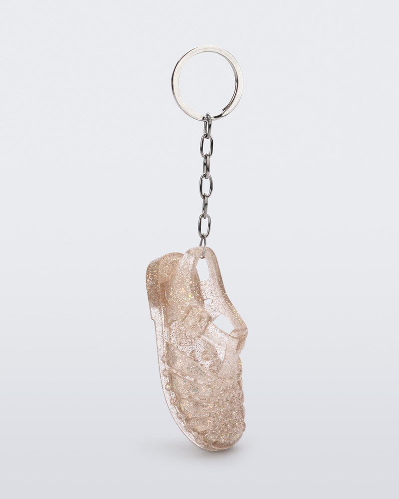 Side angled view of glitter beige Possession keyring