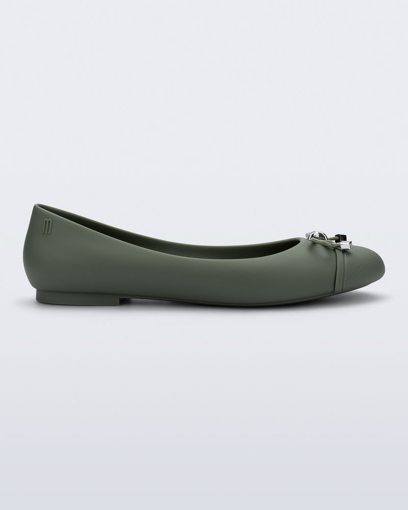 Side view of a green Melissa flat with bow detail with gold accents on the bow