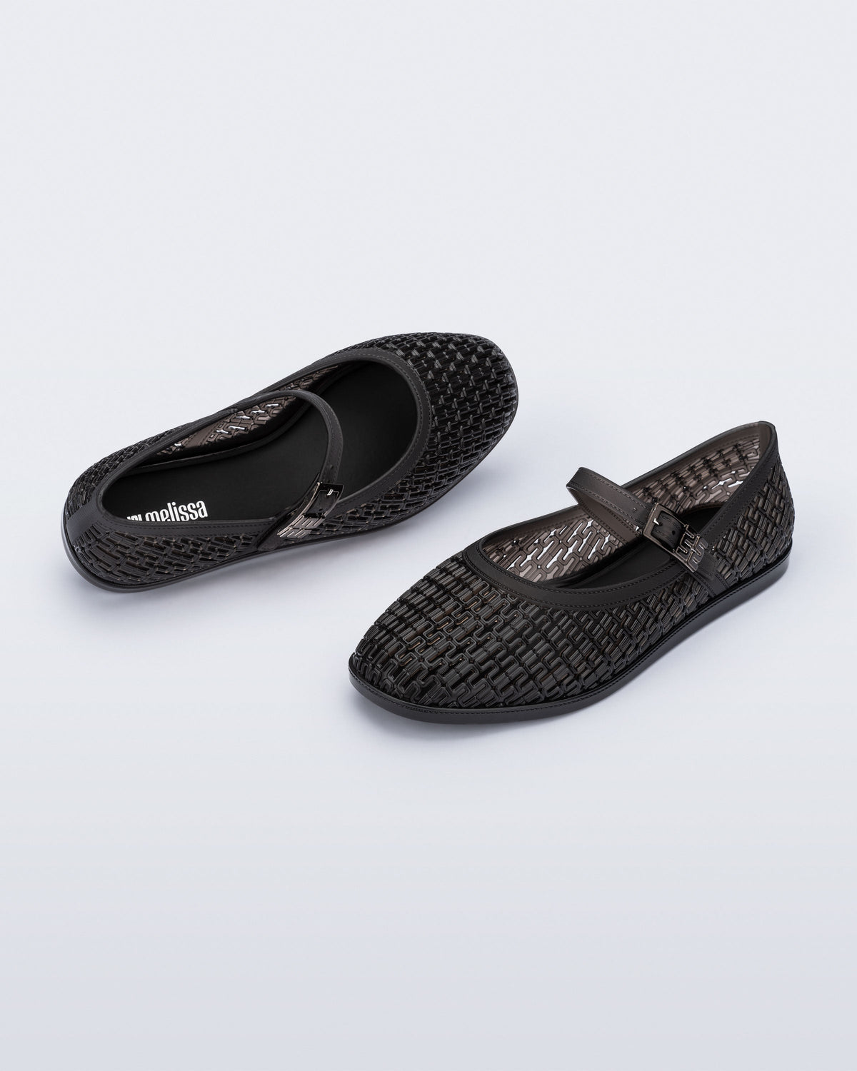 Top and angled view of a pair of clear black Harper flat with strap