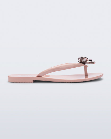 Side view of a pink Harmonic Iris flip flop with rose gold bow
