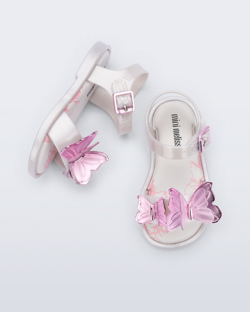 Top and side view of a pair of pearly white baby Butterfly sandals with pink butterflies