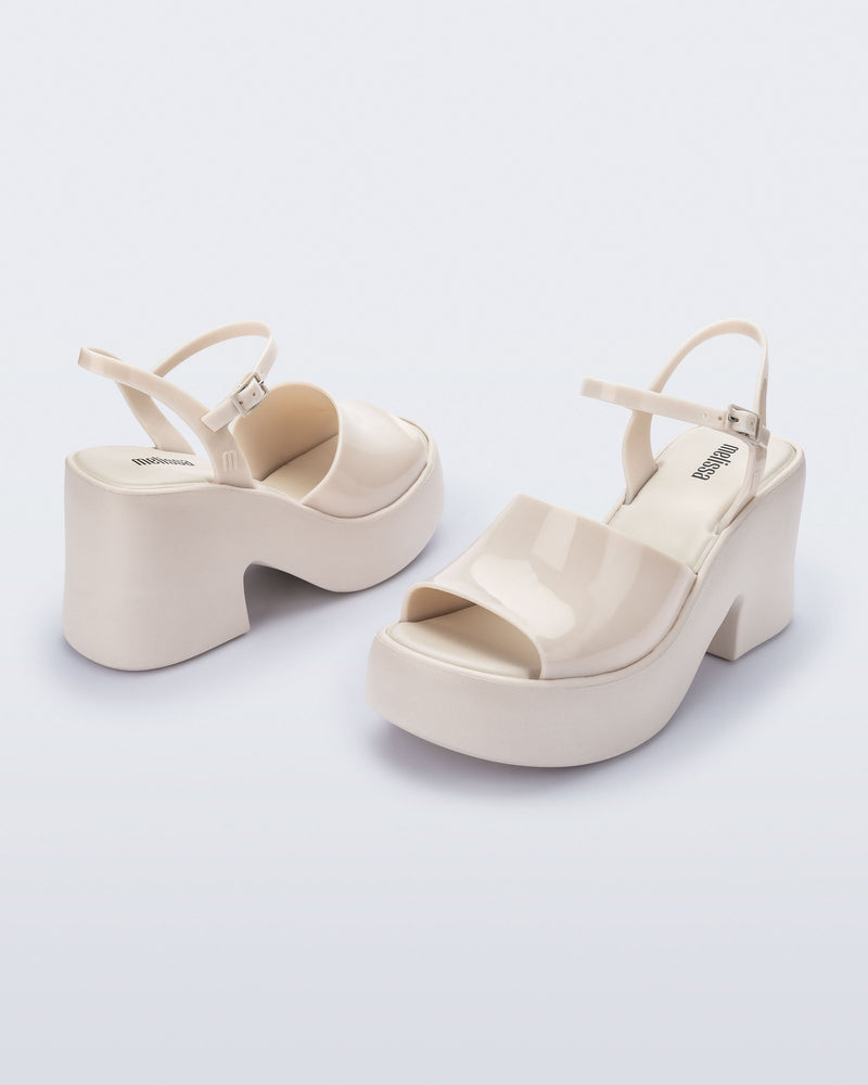 Angled view of a pair of beige  Lina platform heels