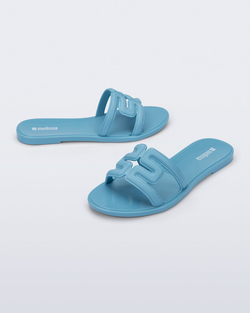 Side and angled view of a pair of blue M Slide sandals