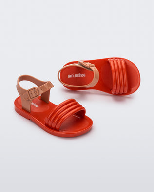 Top and angled view of a pair of red Mar Wave baby sandals with beige strap.