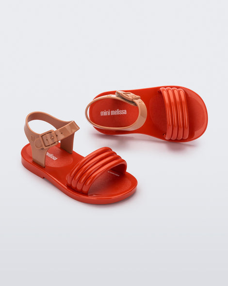 Top and angled view of a pair of red Mar Wave baby sandals with beige strap.