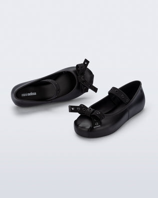 Top and angled view of a pair of black Sophie Crush kids ballerina flats with bow