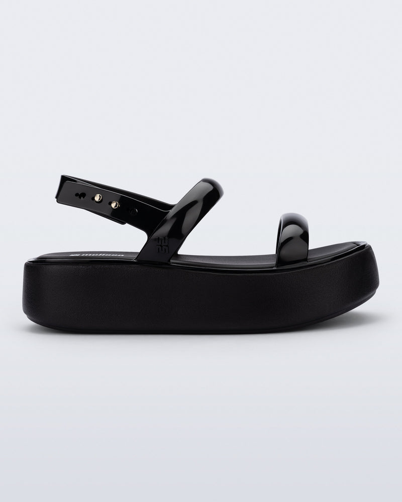 Side view of a black Wave Platform sandal with top and heel straps