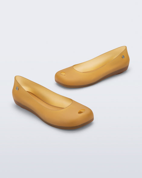 Angled view of a pair of clear yellow Ultragirl Futura ballerina flats