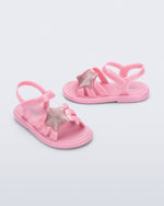 Side and angled view of a pair of pearly pink Hip Sky baby sandals with a glitter pink star on top