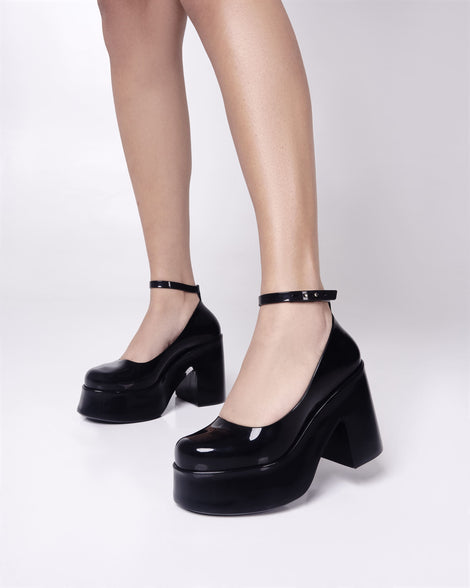 Model's legs wearing a pair of black Melissa Doll Heel platforms with ankle strap.