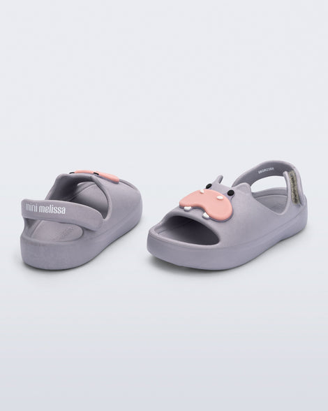 Back and angled view of a pair of grey Free Cute baby sandals with hippo face on front upper 