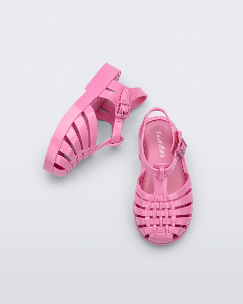 A top and side view of a pair of pink Mini Melissa Possession sandals with a fisherman sandal design