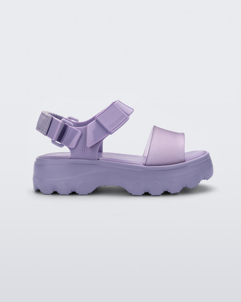Side view of a Mini Melissa Kick Off platform sandal in lilac with adjustable velcro ankle strap.