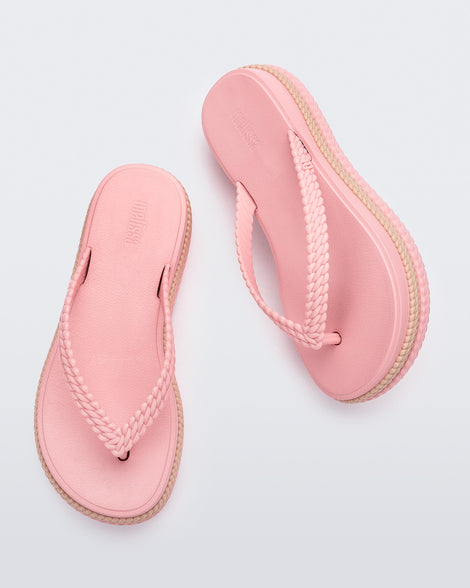 Top view of a pair of pink/beige Melissa Leblon platform flip flops with details that mimic sisal braids on the sole and strap